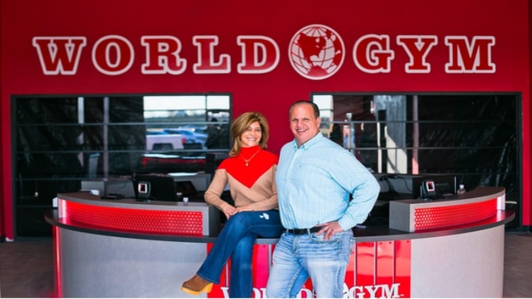 A picture of Jerome Karam with his wife Leslie in front of the world’s largest World Gym.